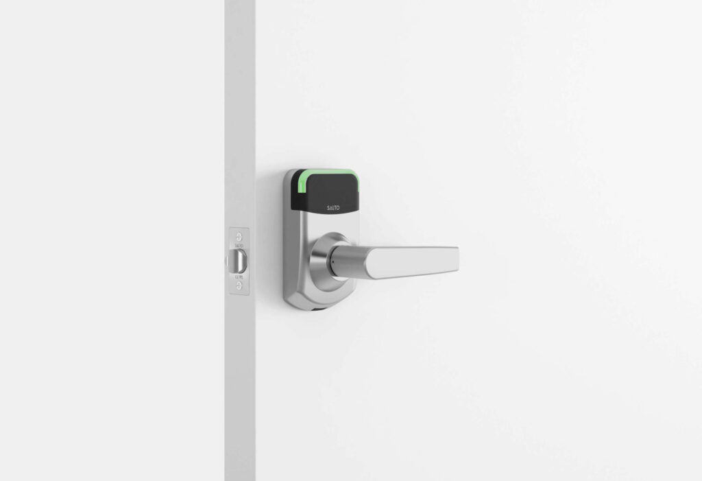 A door fitted with a silver XS4 MINI - ANSI smart lock featuring a rectangular black touchpad and lever handle